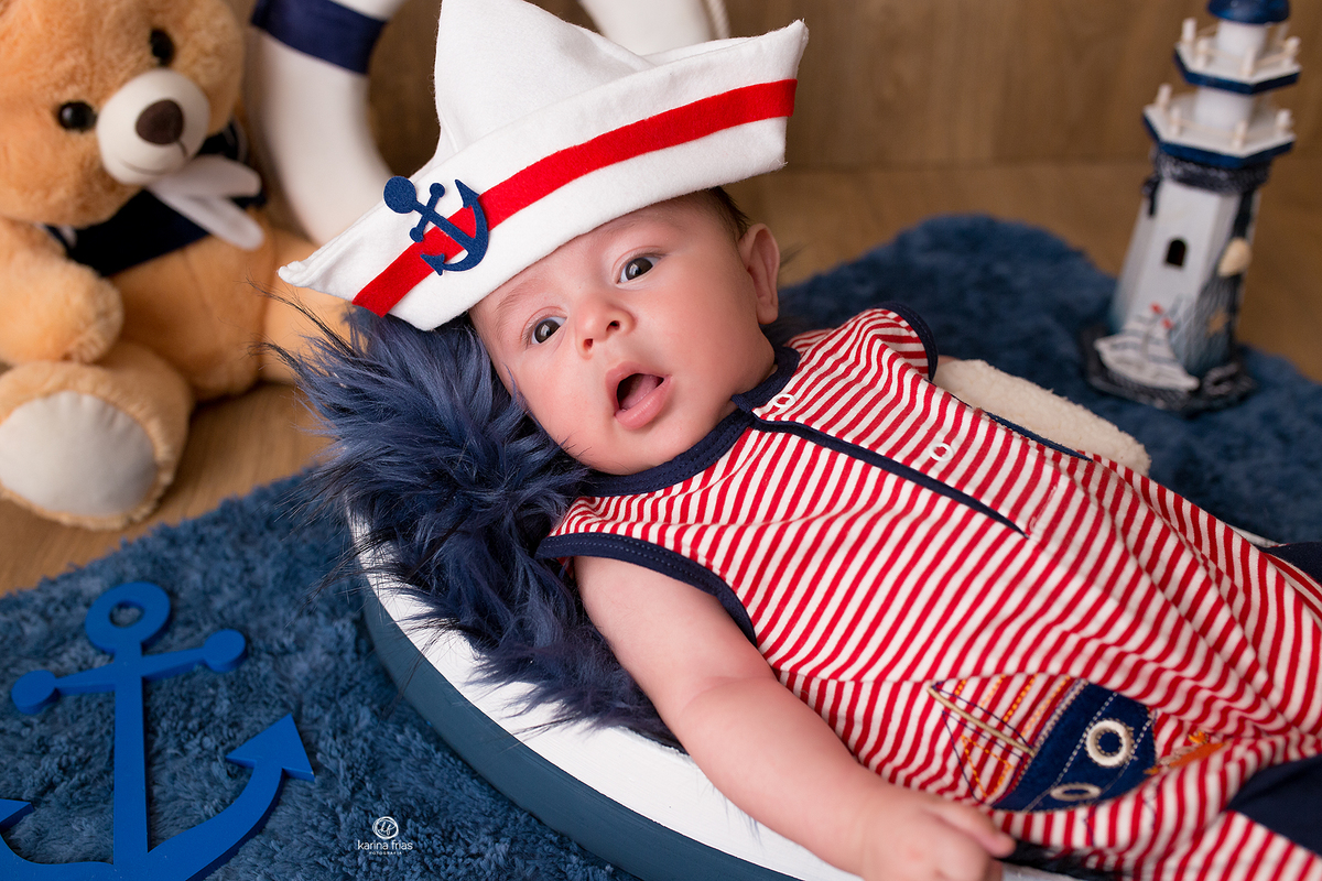 o bebe esta no cenario de marinheiro para as fotos do acompanhamento mensal