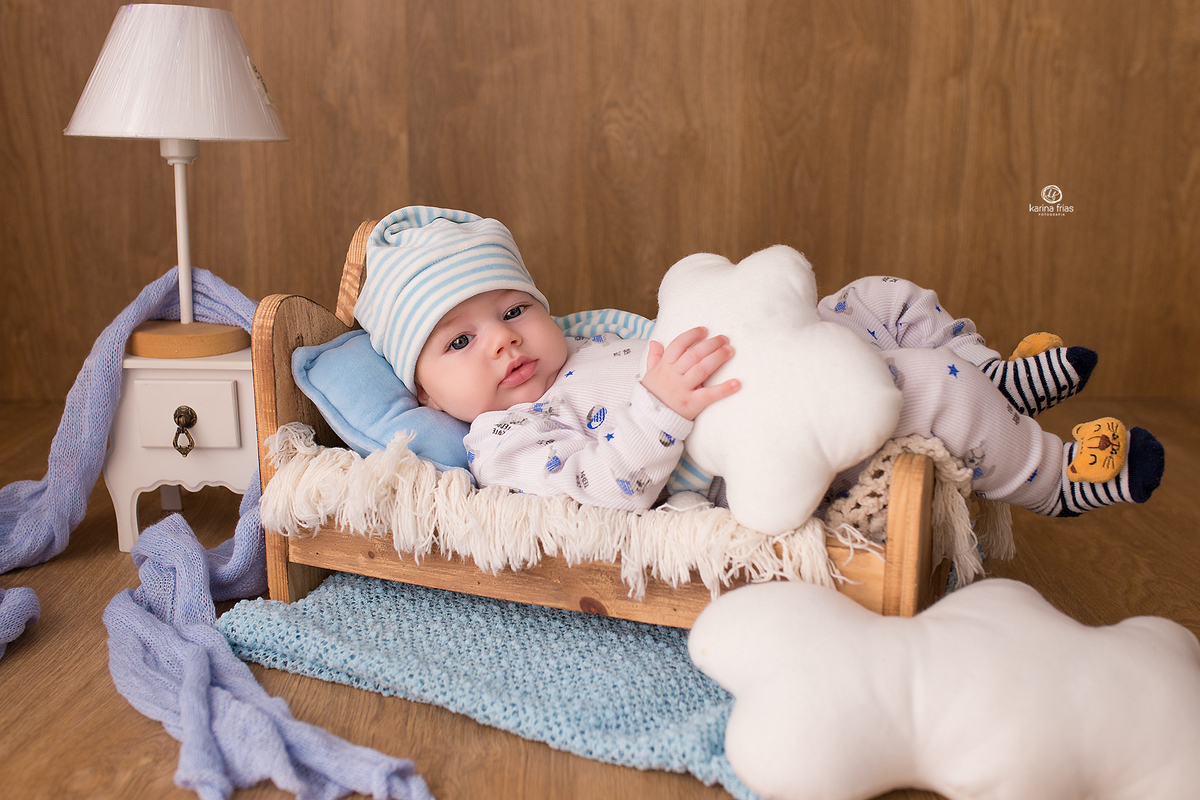 o menino esta deitado na cama para a fotos do acompanhamento mensal