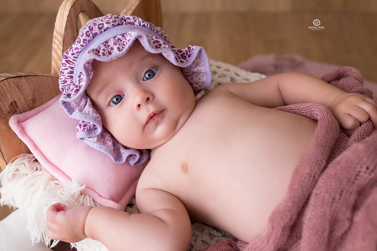 a menina esta deitada na cama para as fotos do acompanhamento mensal