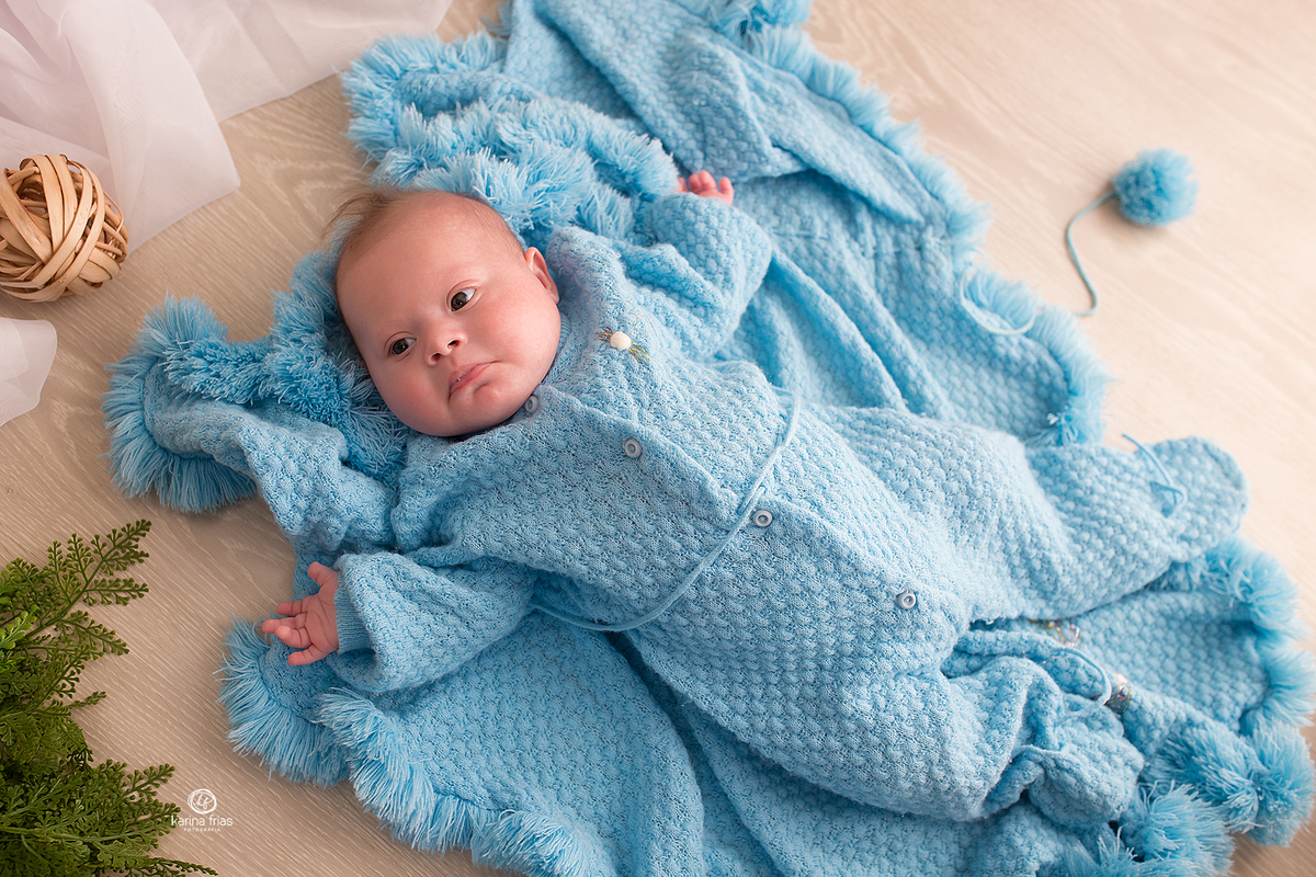 o menino esta deitado para as fotos do acompanhamento mensal