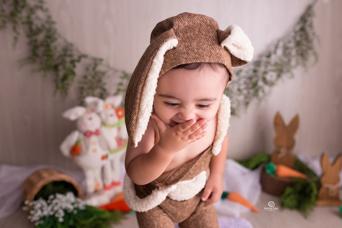 a criança poe a mao na boca no ensaio de pascoa 2021