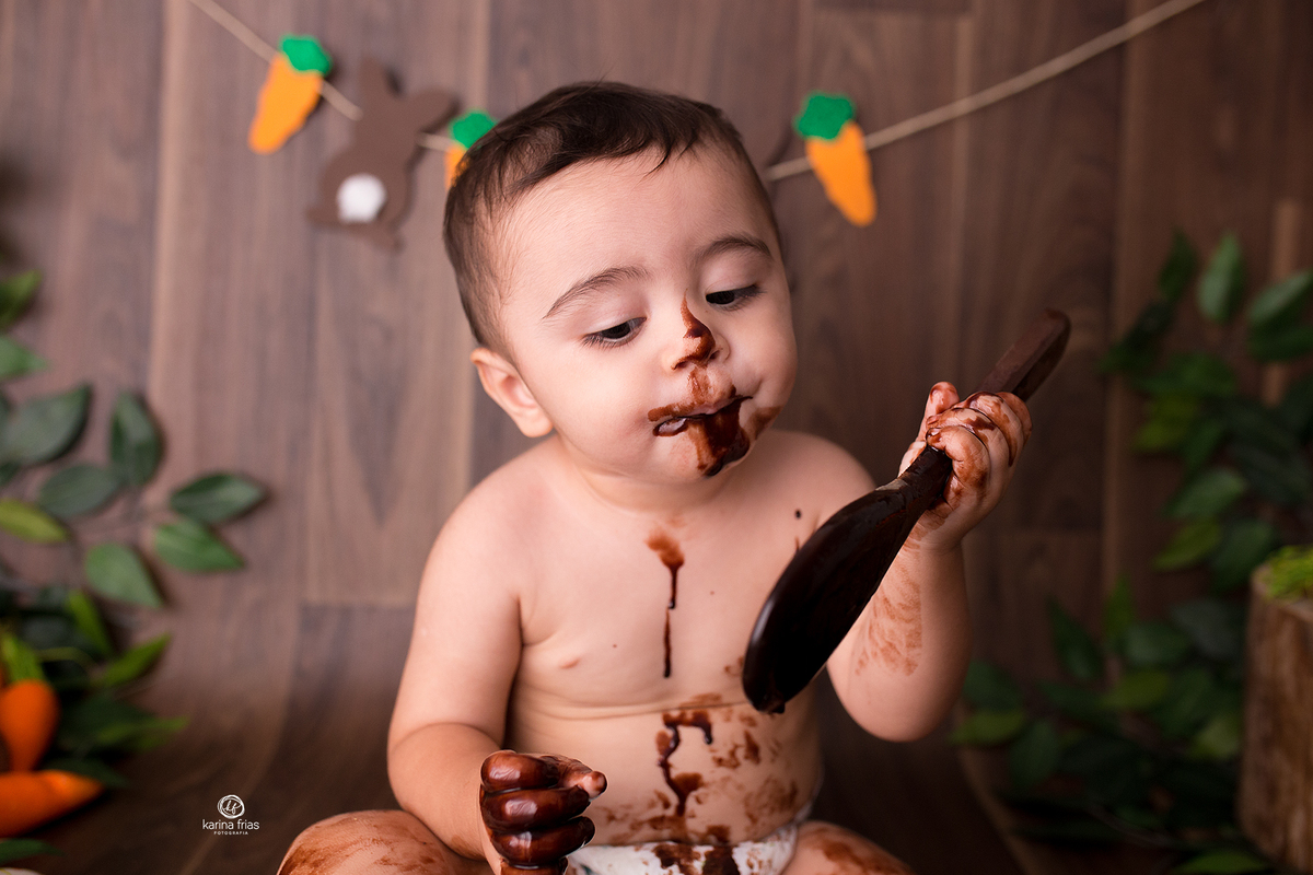 o menino come chocolate na sessão de pascoa