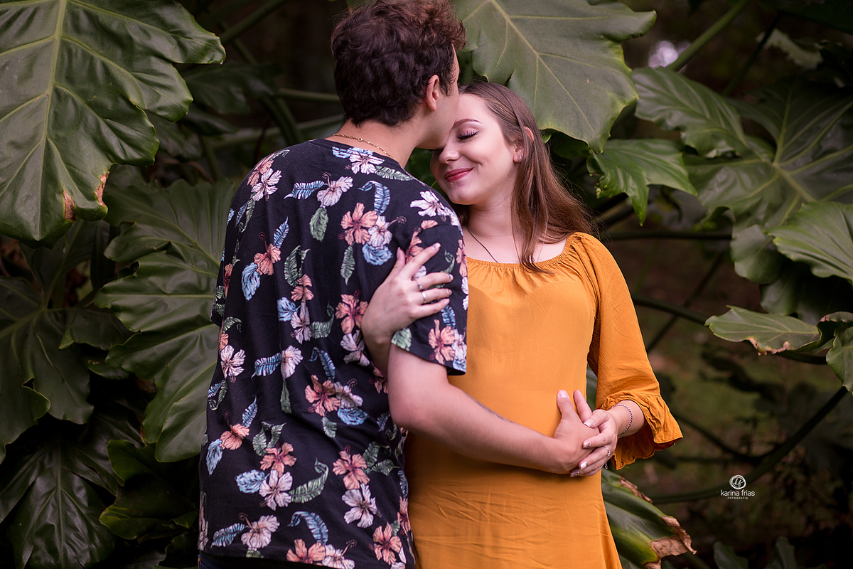 o pai beija a testa da gestante na sessão de fotos