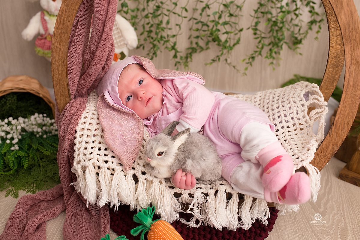 a menina abraça o coelho na sessão de pascoa 2021