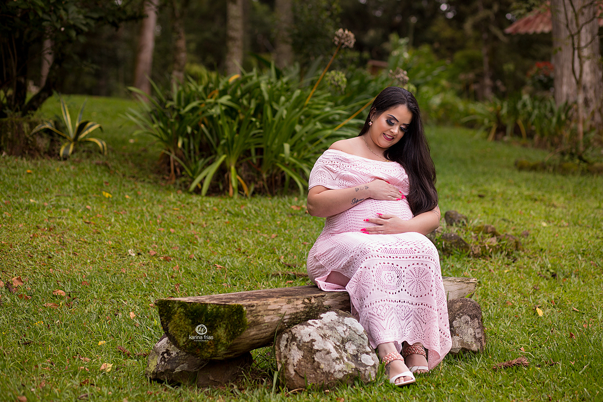 a gestante olha para a barriga no ensaio externo