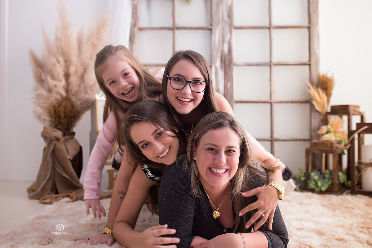a mae e as filhas brincam na sessão de fotos de maes