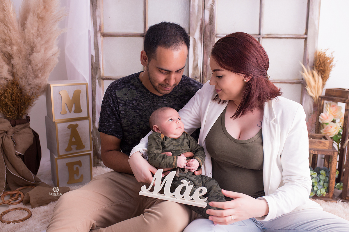 os pais olham para o filho na sessão de dia das maes