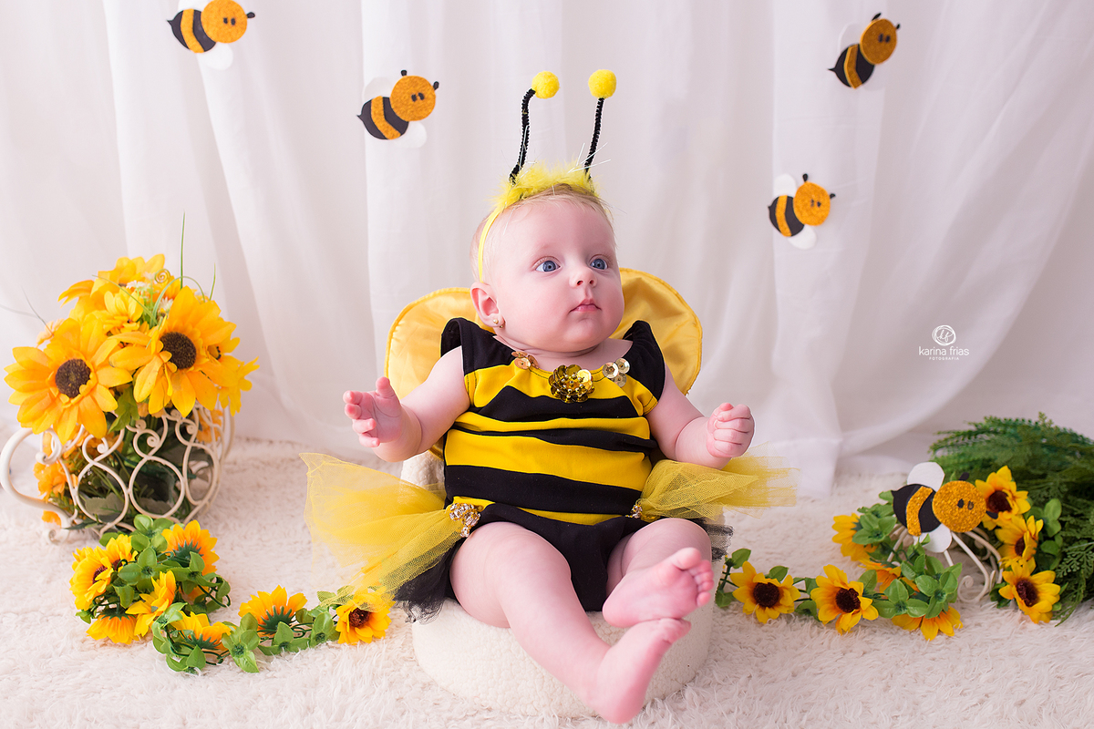 a menina esta vestida de abelhinha para as fotos de acompanhamento mensal