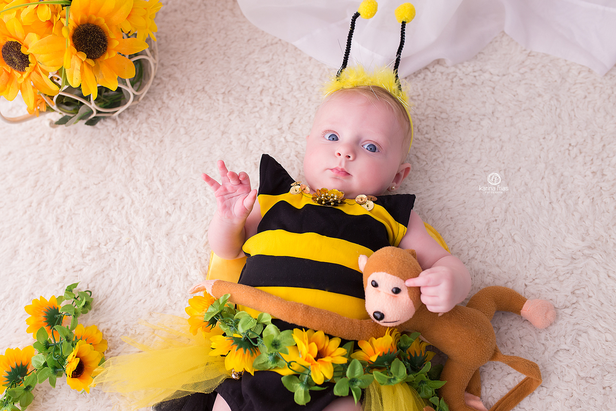 a menina olha para a camera durante a sessão de abelhinha