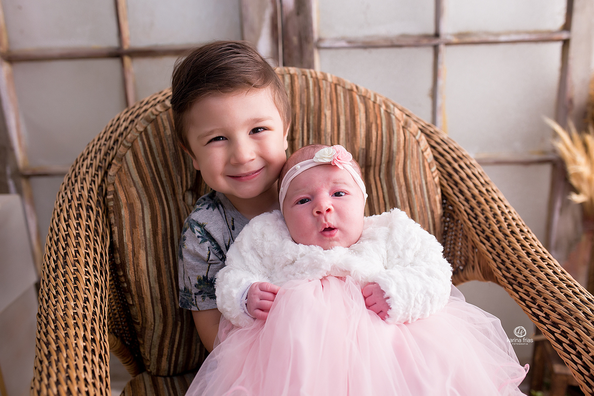 o irmao segura a irma na sessão de fotos