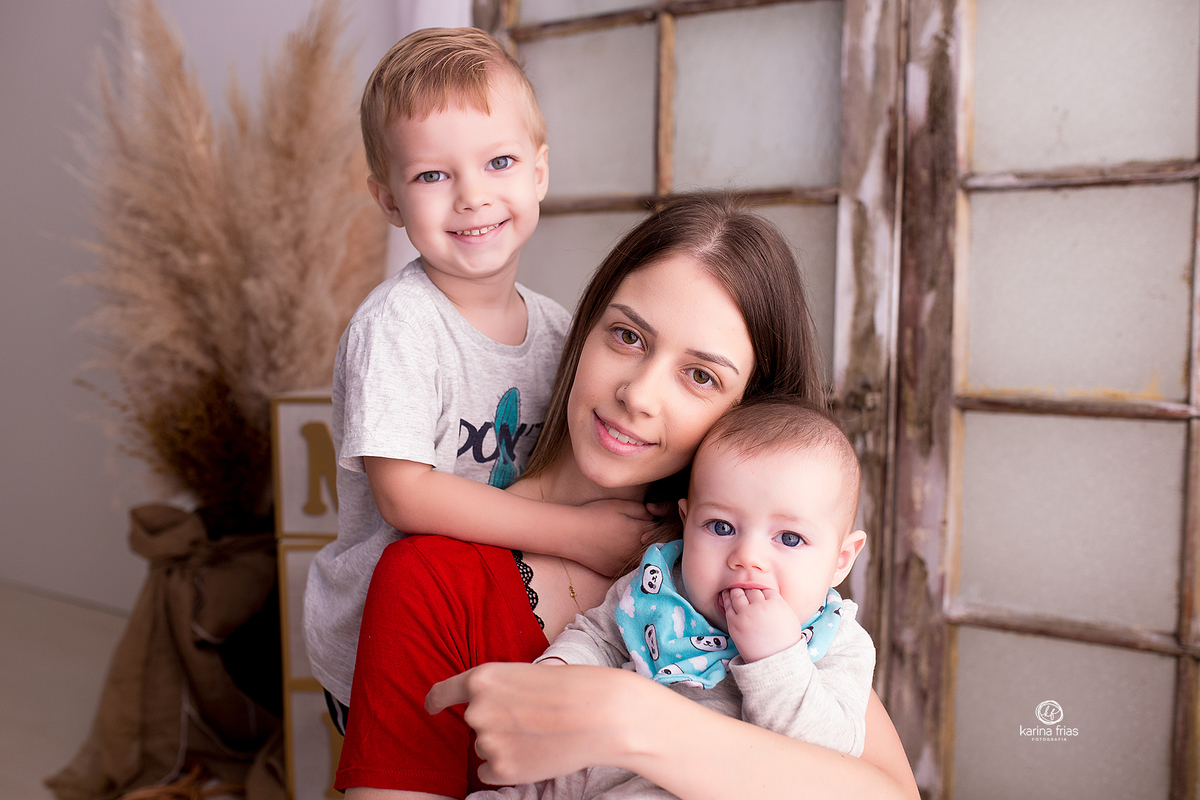 a mãe abraça os filhos na sessão de fotos
