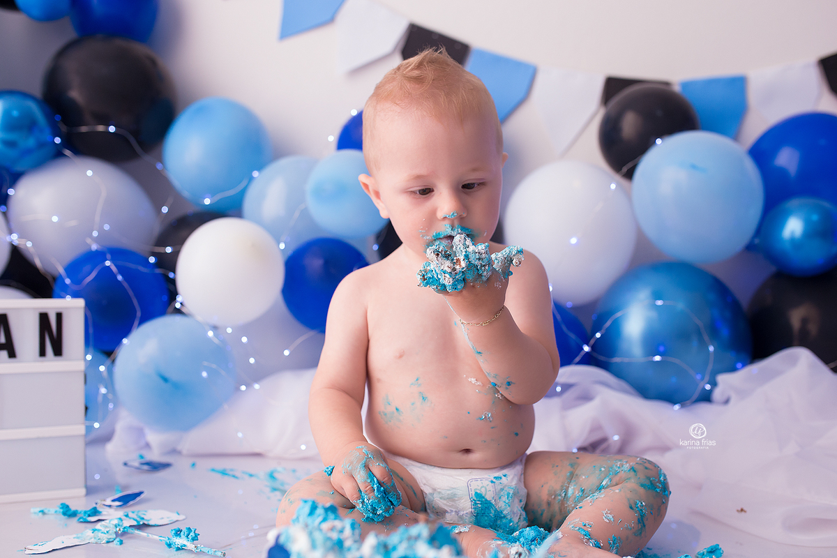 o bebe olha a mao suja de bolo