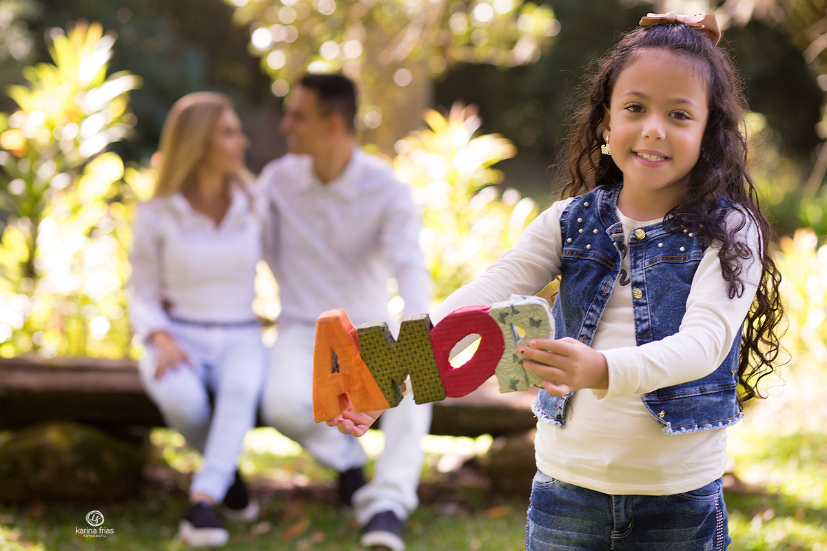 a menina segura a plaquinha do amor durante sessão de fotos