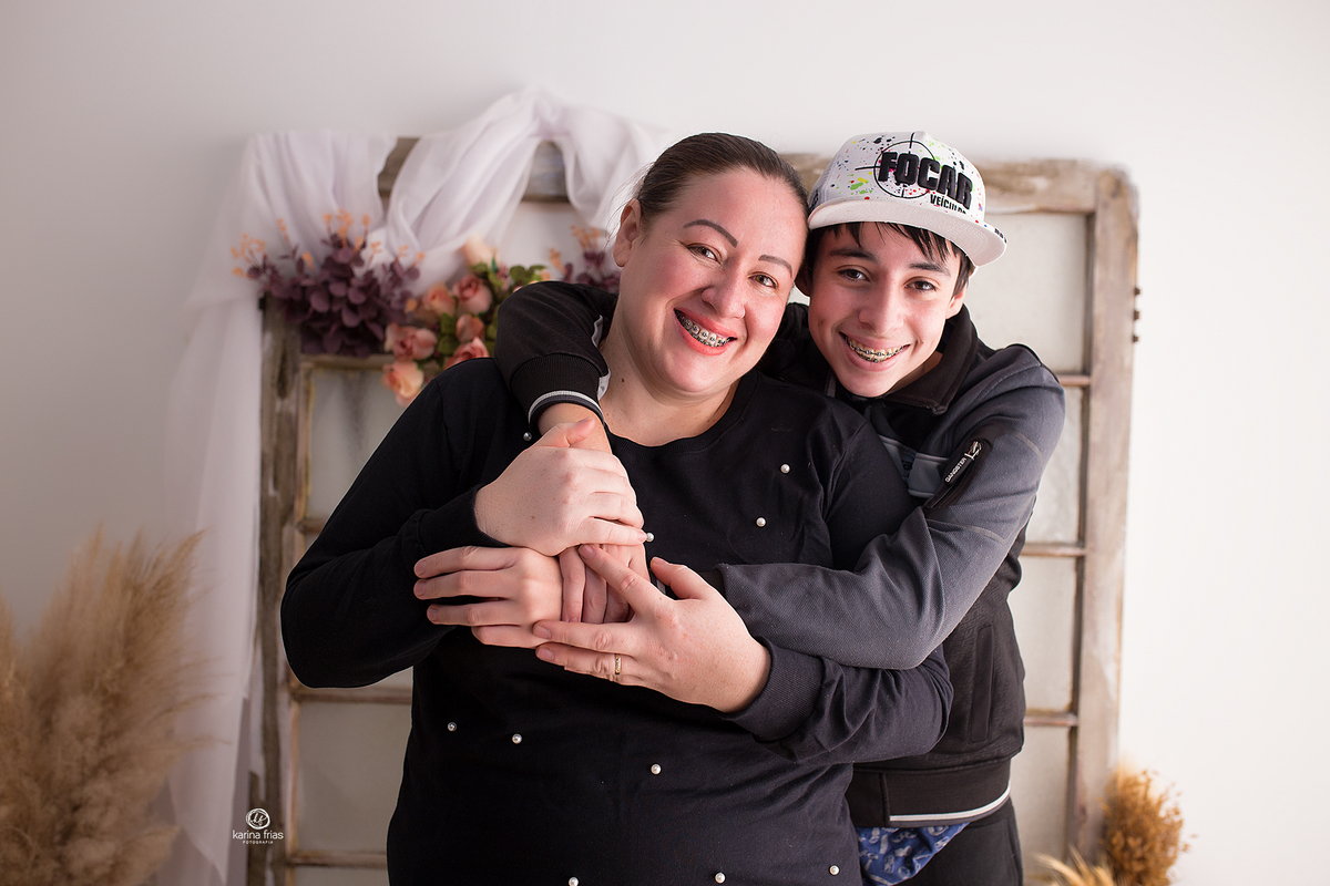 o filho mais velho abraça a mae no book em estudio