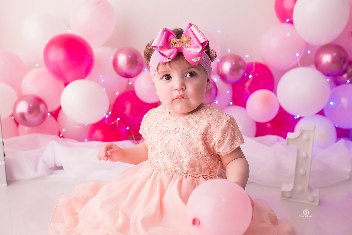 no ensaio de um ano, a menina olha para a fotografa de bebes de caxias do sul, karina frias