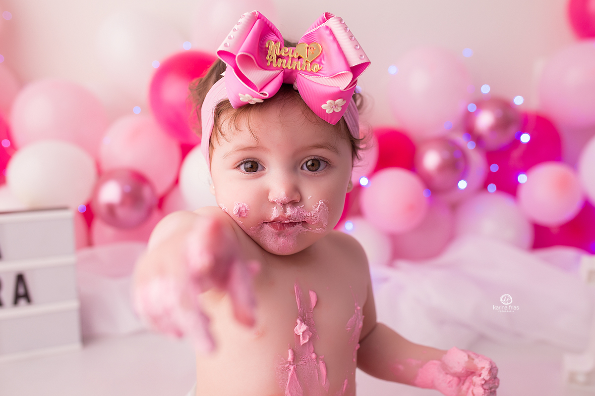 a menina aponta a camera toda suja nas fotos de um ano