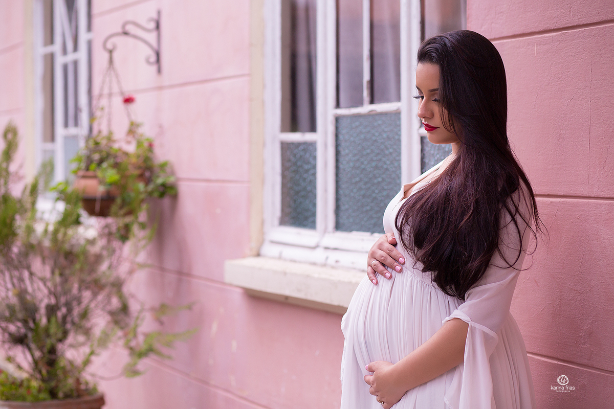 a gestante olha para a barriga no ensaio externo
