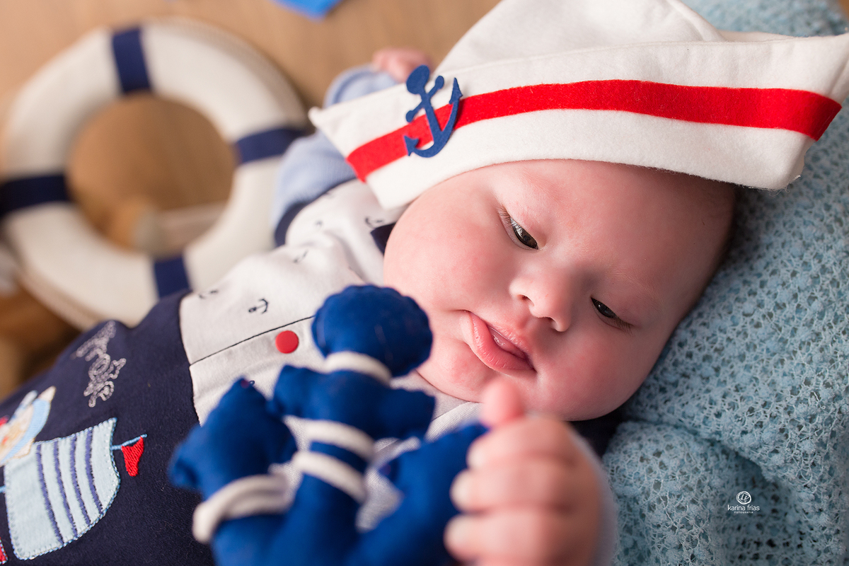 o menino brinca com a ancora no ensaio de acompanhamento mensal