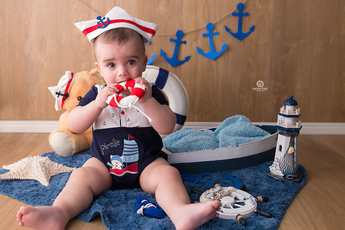 o menino esta vestido de marinheiro para as fotos mensais