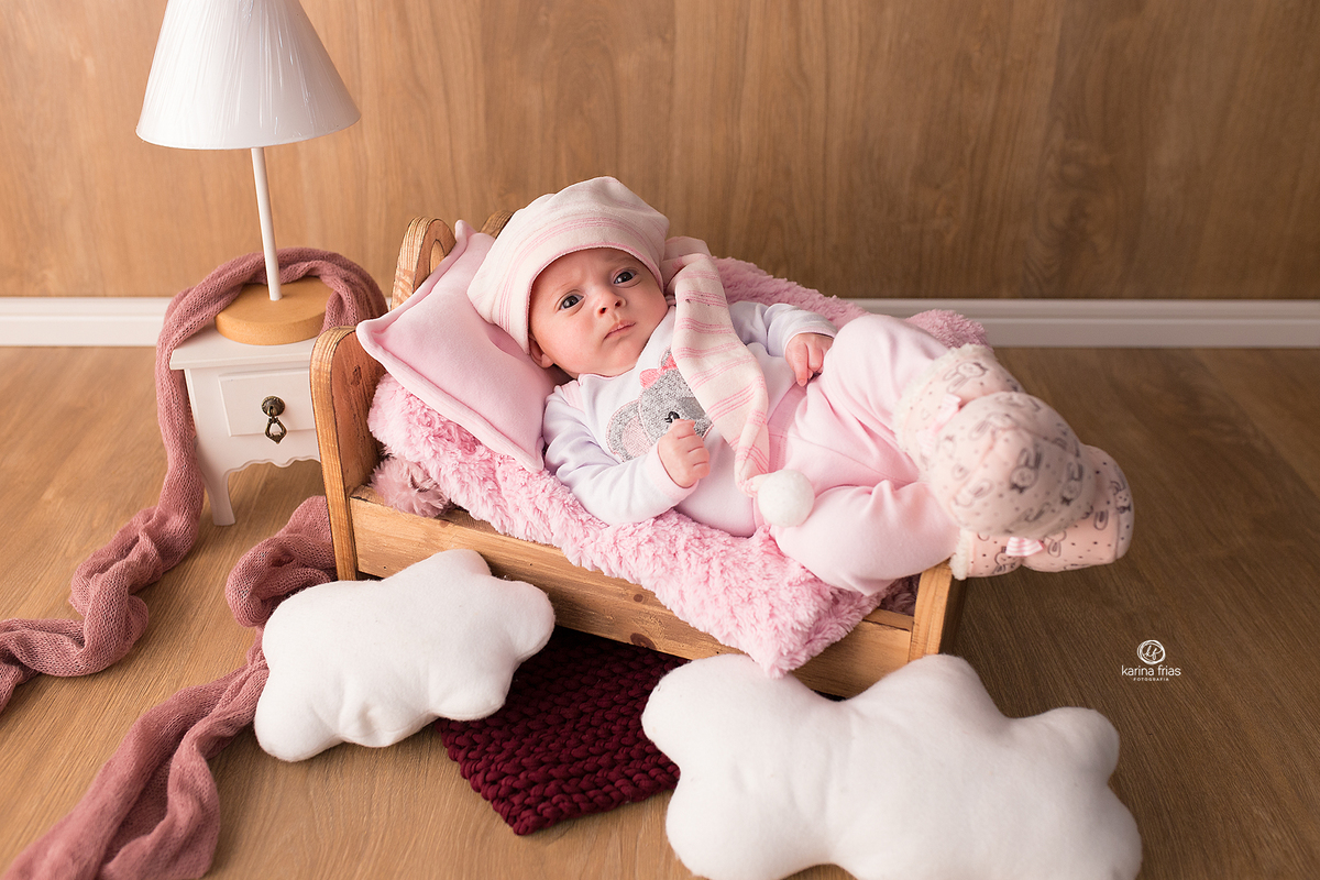 a bebe esta deitada na caminha para as fotos do acompanhamento mensal