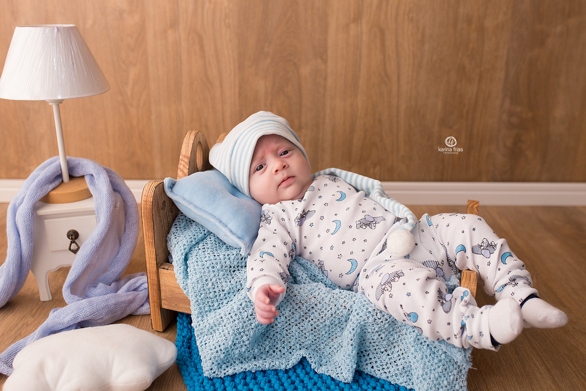o menino esta deitado na cama para as fotos do acompanhamento mensal