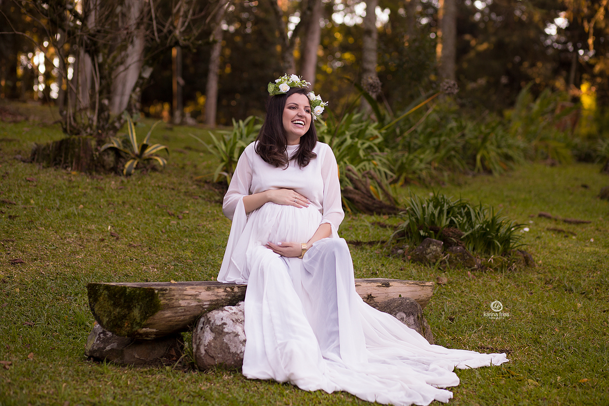 a modelo sorri durante as fotos de gestante