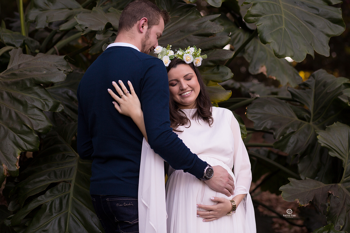os pais se abraçam no ensaio de gestante externo