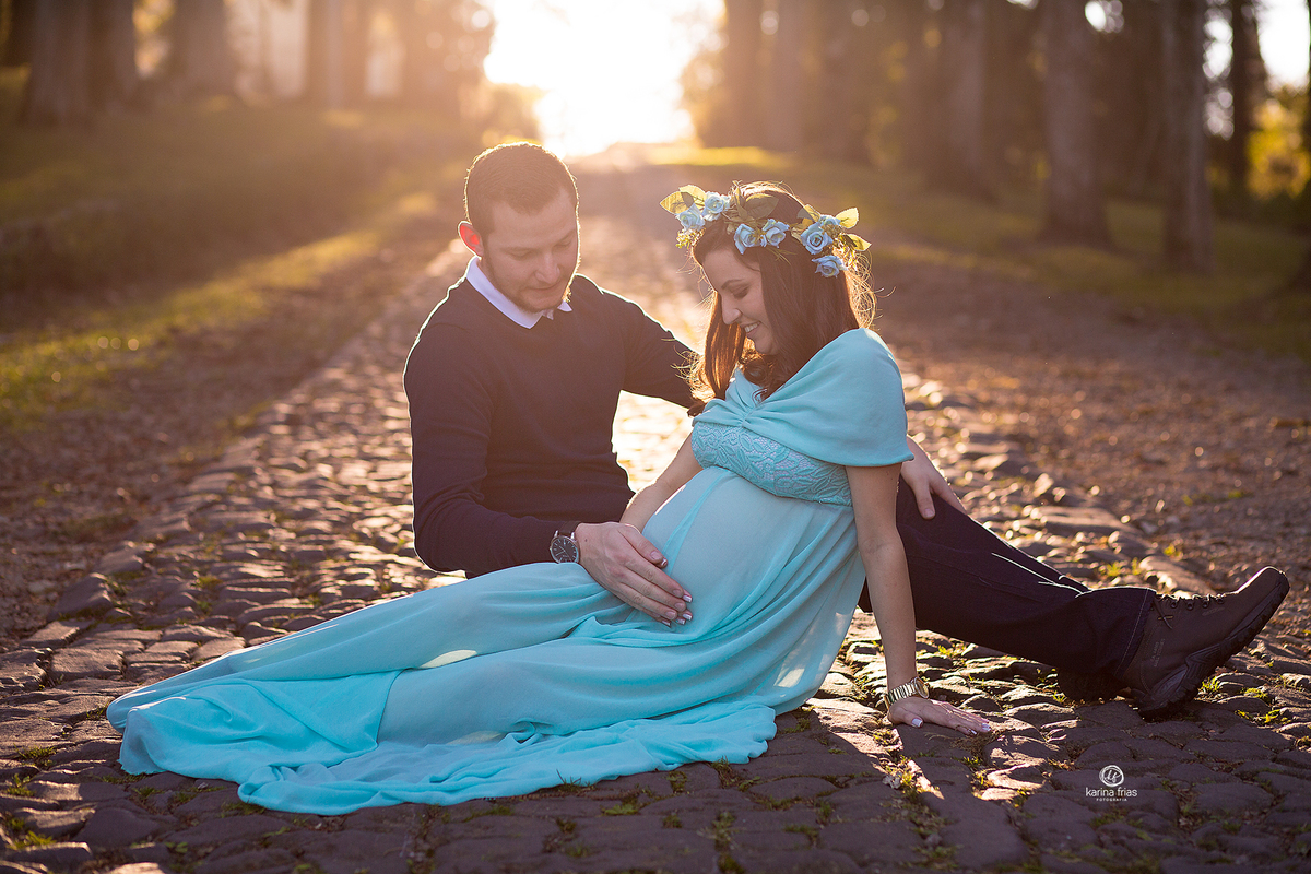 no ensaio de gestante os pais olham para a barriga da mae