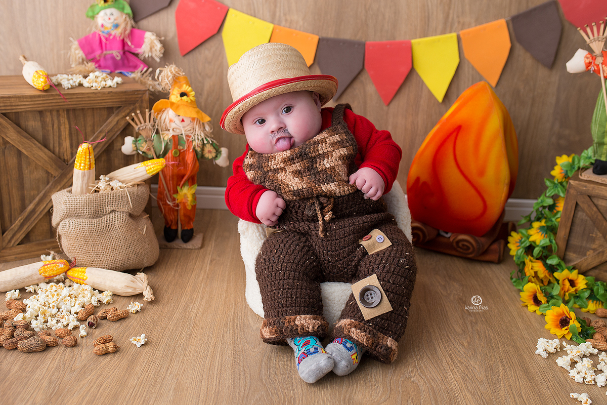 o menino esta vestido de caipira para as fotos mensais