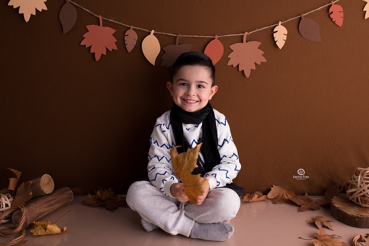 o menino sorri para a fotografa de crianças de caxias do sul, karina frias