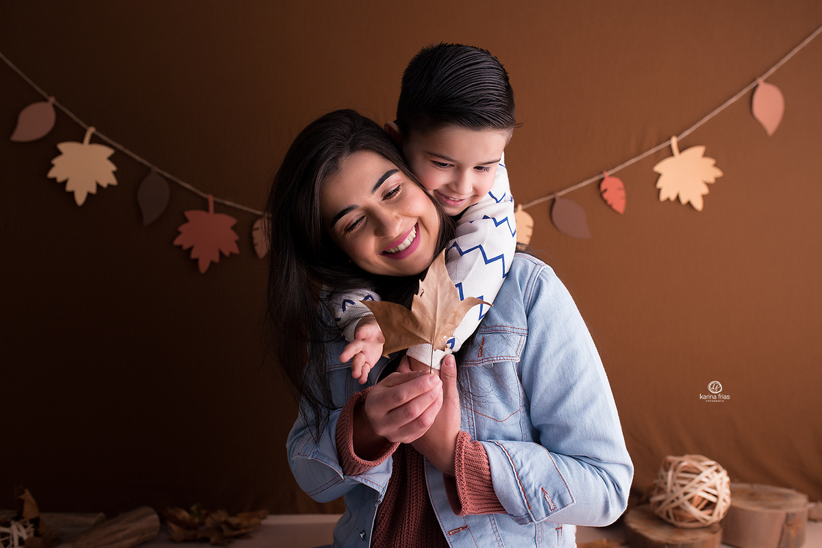 mae e filho fazem fotos no cenario de outono