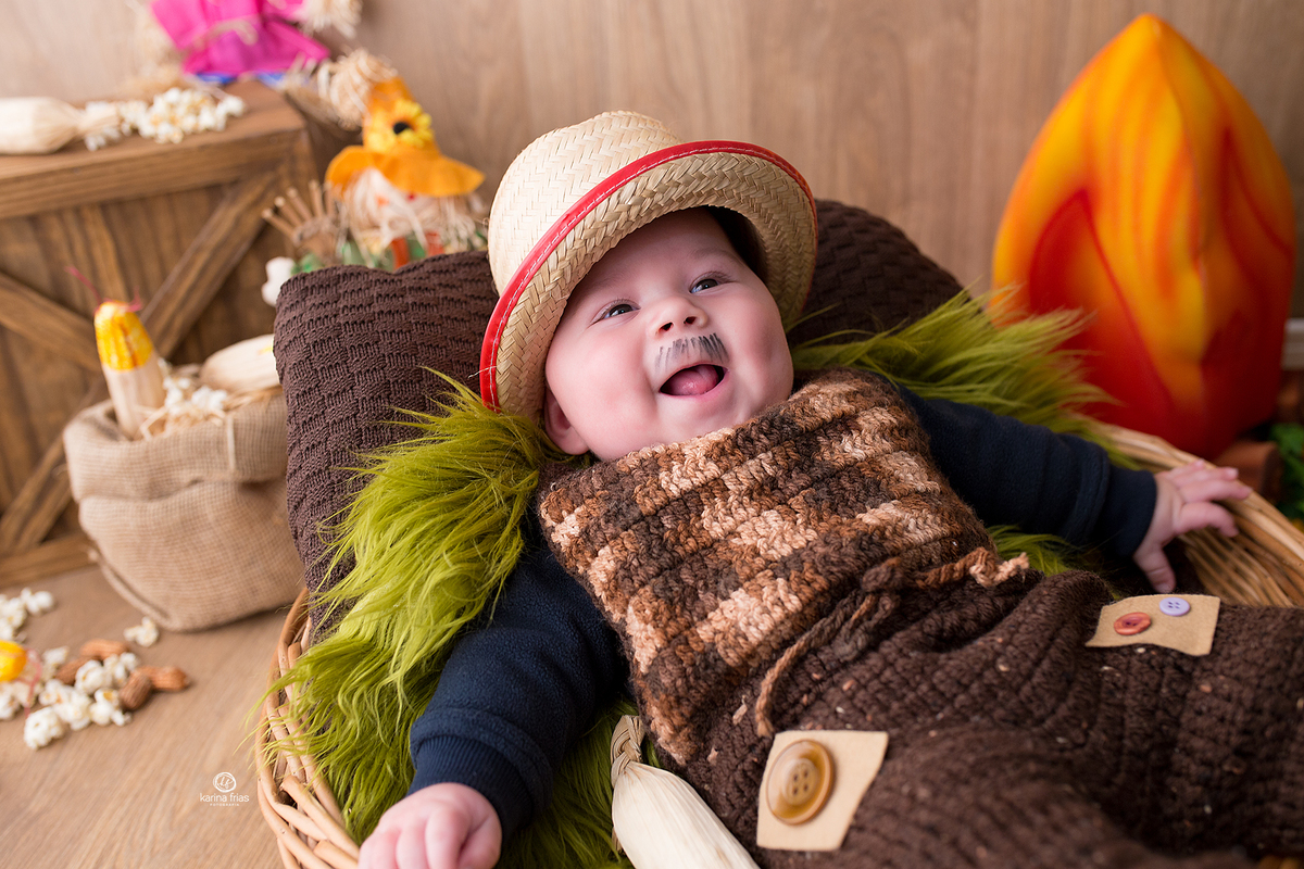 o menino sorri enquanto a fotografa de bebes de caxias do sul, ka frias registra o momento