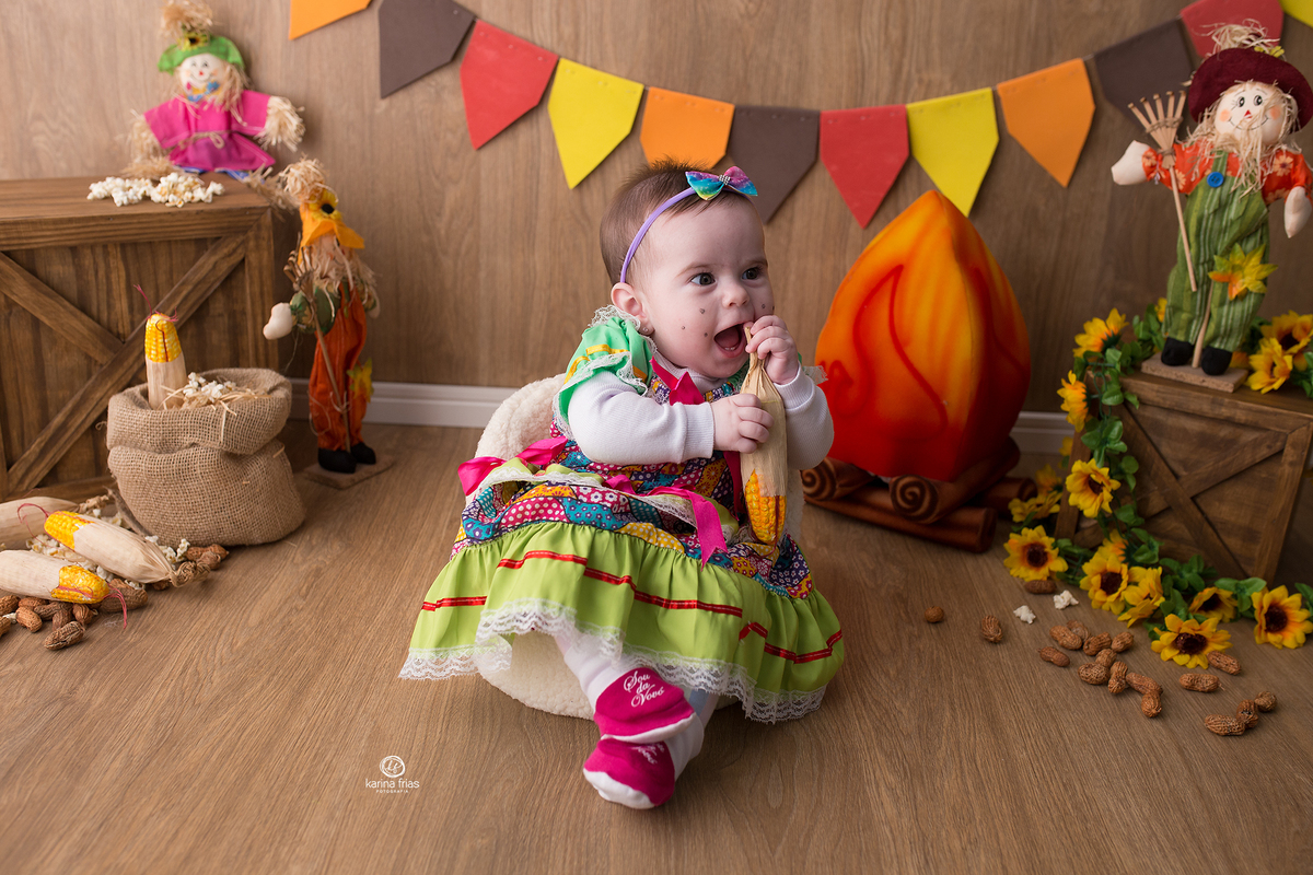 a menina brinca com o milho na sessão de festa junina