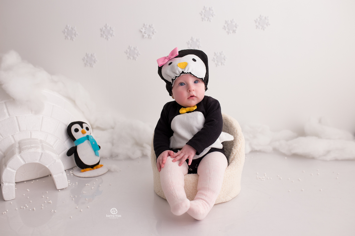 a menina esta vestida de pinguim para as fotos de acompanhamento mensal