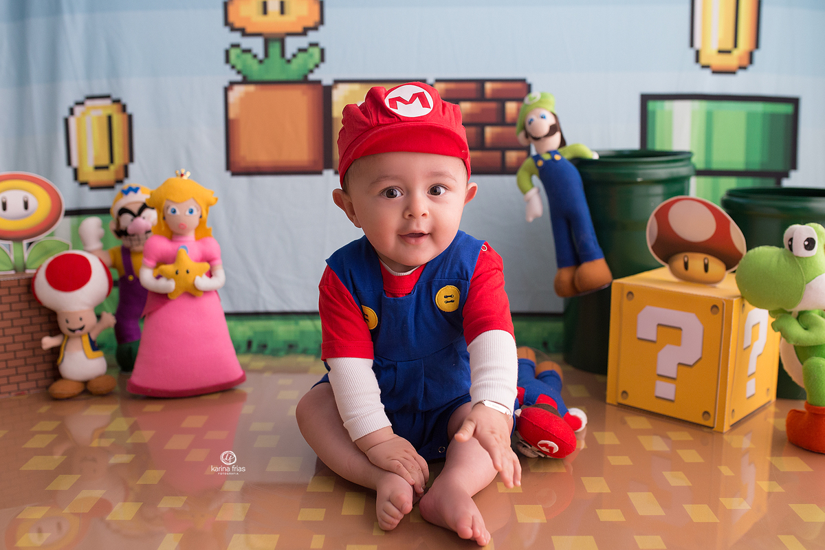 o menino esta vestido de mario bros para as fotos mensais