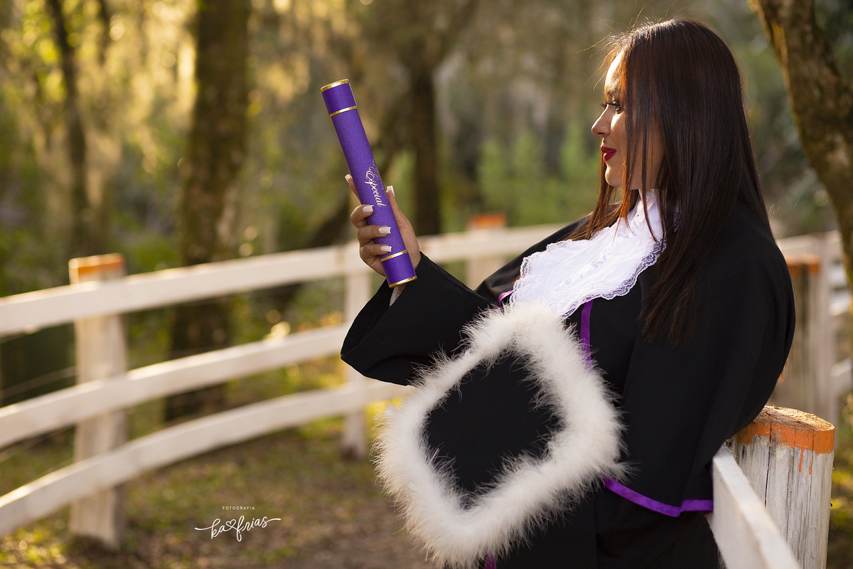 no ensaio de formatura, a modelo segura o canudo