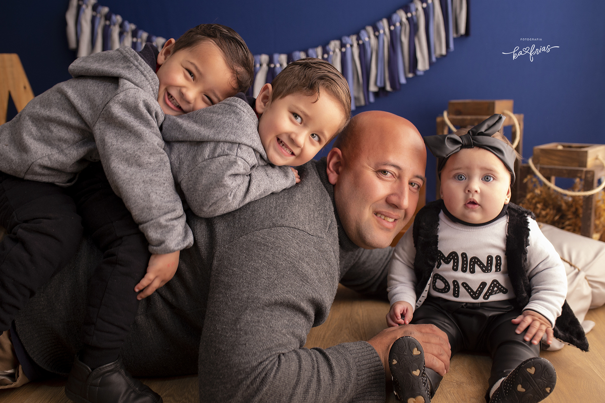 o pai brinca com as crianças durante sessão de fotos