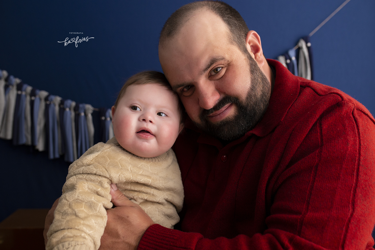 o pai segura o bebe no colo para a sessão de dia dos pais 2021