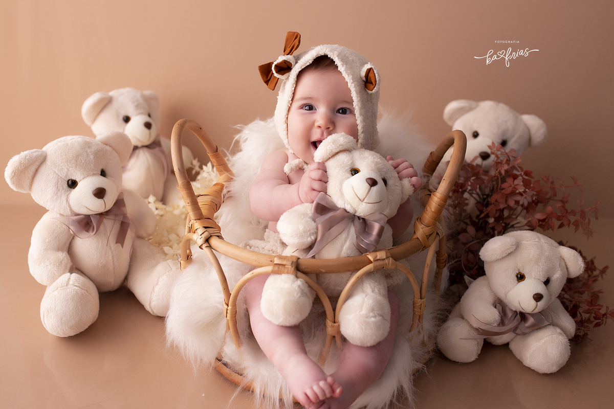 no ensaio infantil, a bebe segura o ursinho