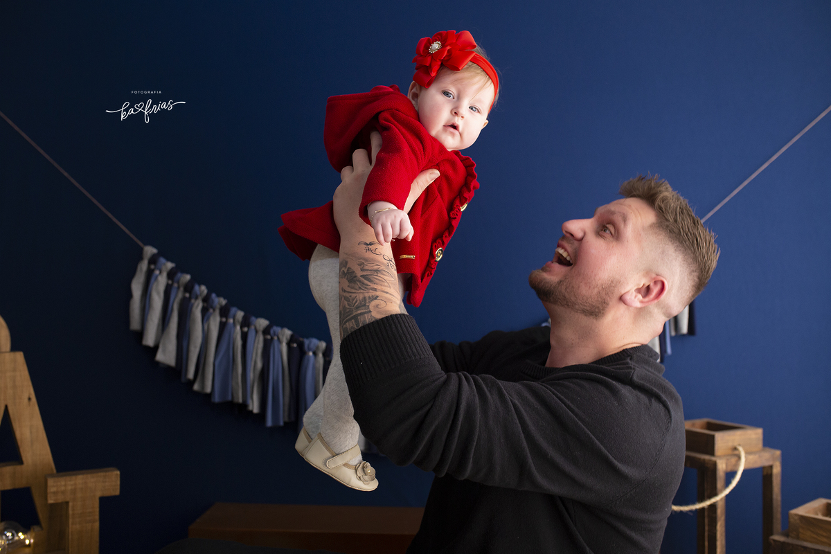 nas fotos de dia dos pais o pai brinca com a bebe no estudio em caxias do sul-rs