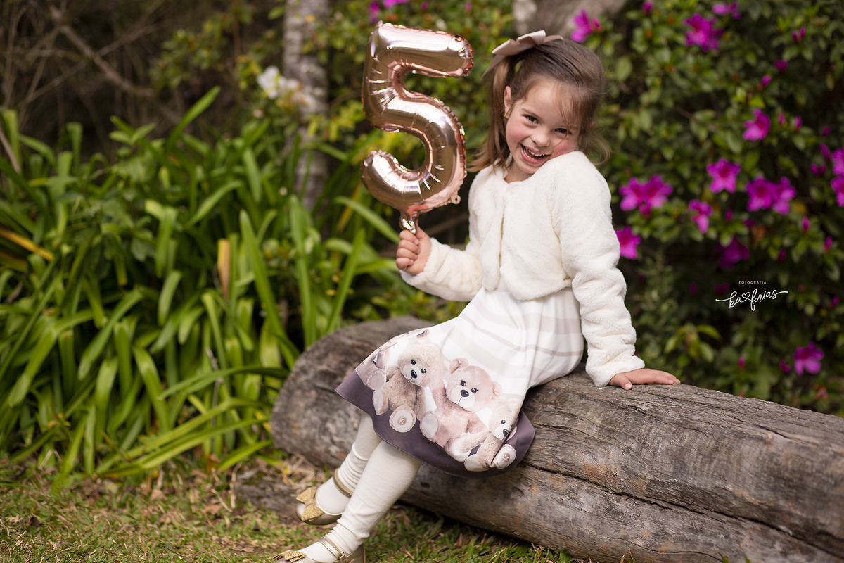 no ensaio de aniversario, a menina segura o numero com sua idade