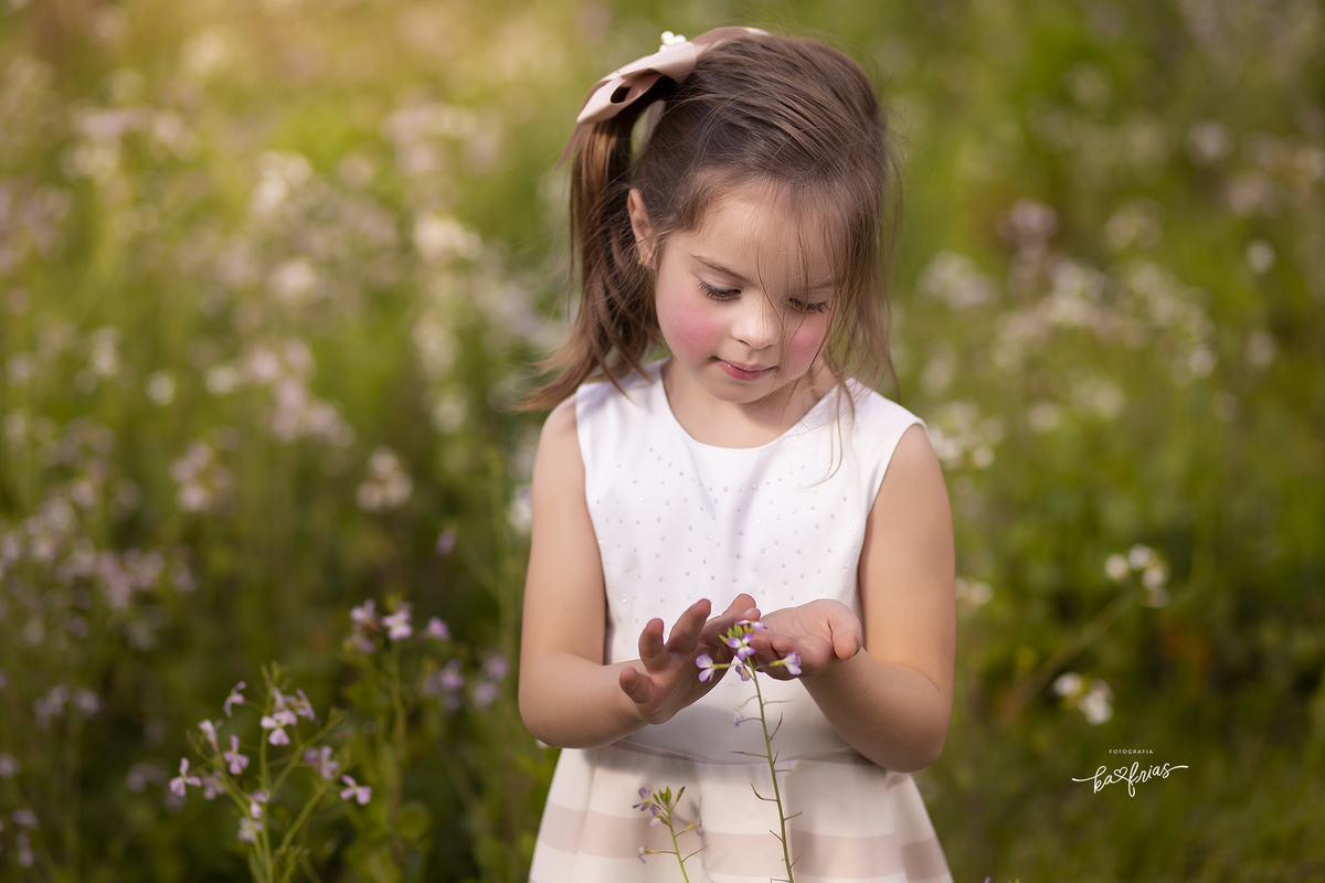 a menina mexe nas flores durante as fotos
