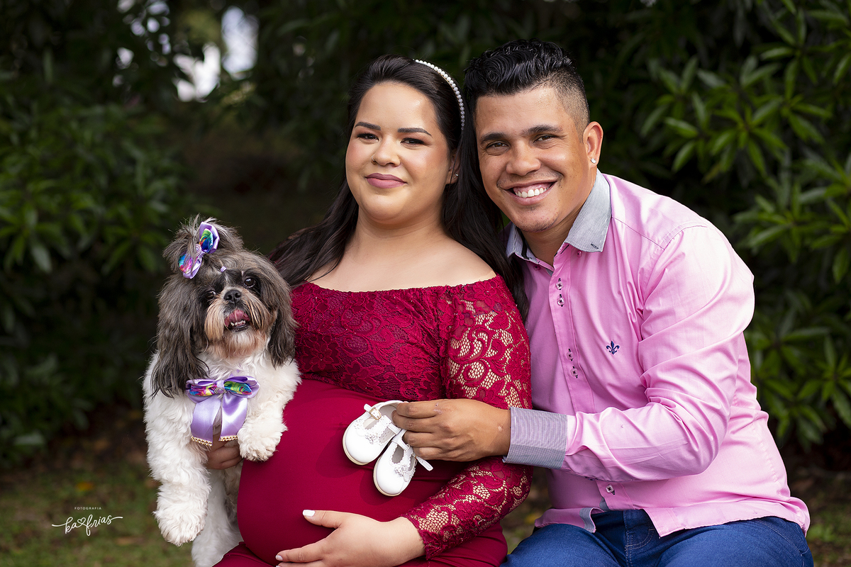 os pais posam junto com a cachorrinha na sessão de fotos