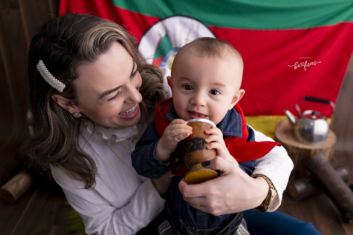 o menino sorri com a mae enquanto a fotografa de caxias do sul registra o momento