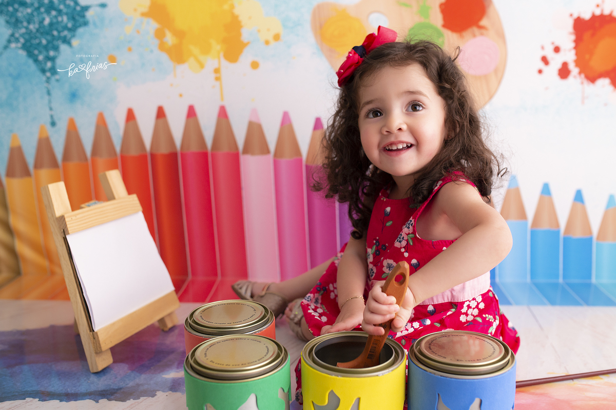no ensaio infantil a menina mexe a tinta