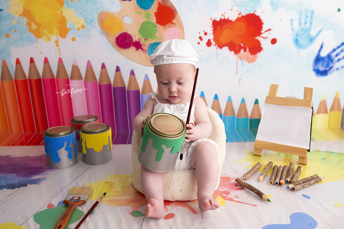 no ensaio de aquarela, o bebe segura a lata de tinta