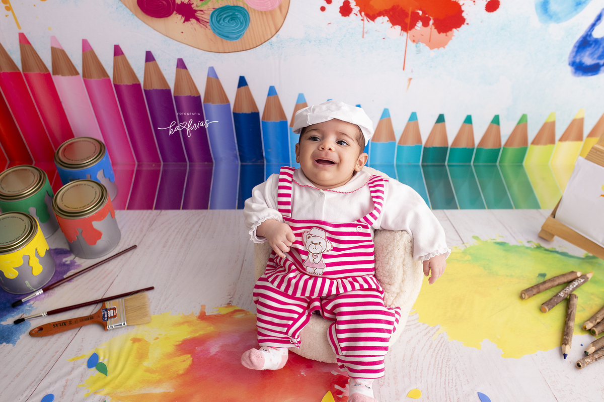 a menina esta sorrindo para a fotografa de bebes de caxias do sul, ka frias