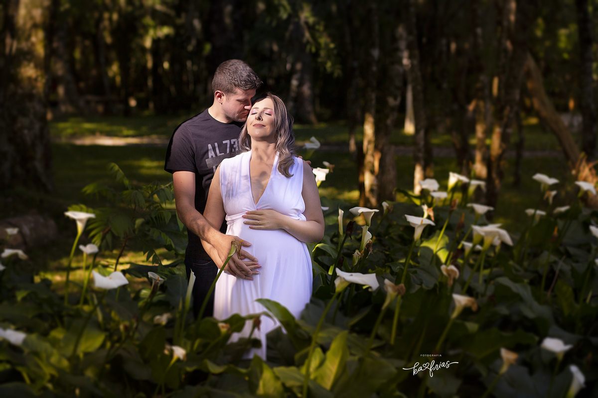 os pais estao em meio aos lirios no ensaio de gestante