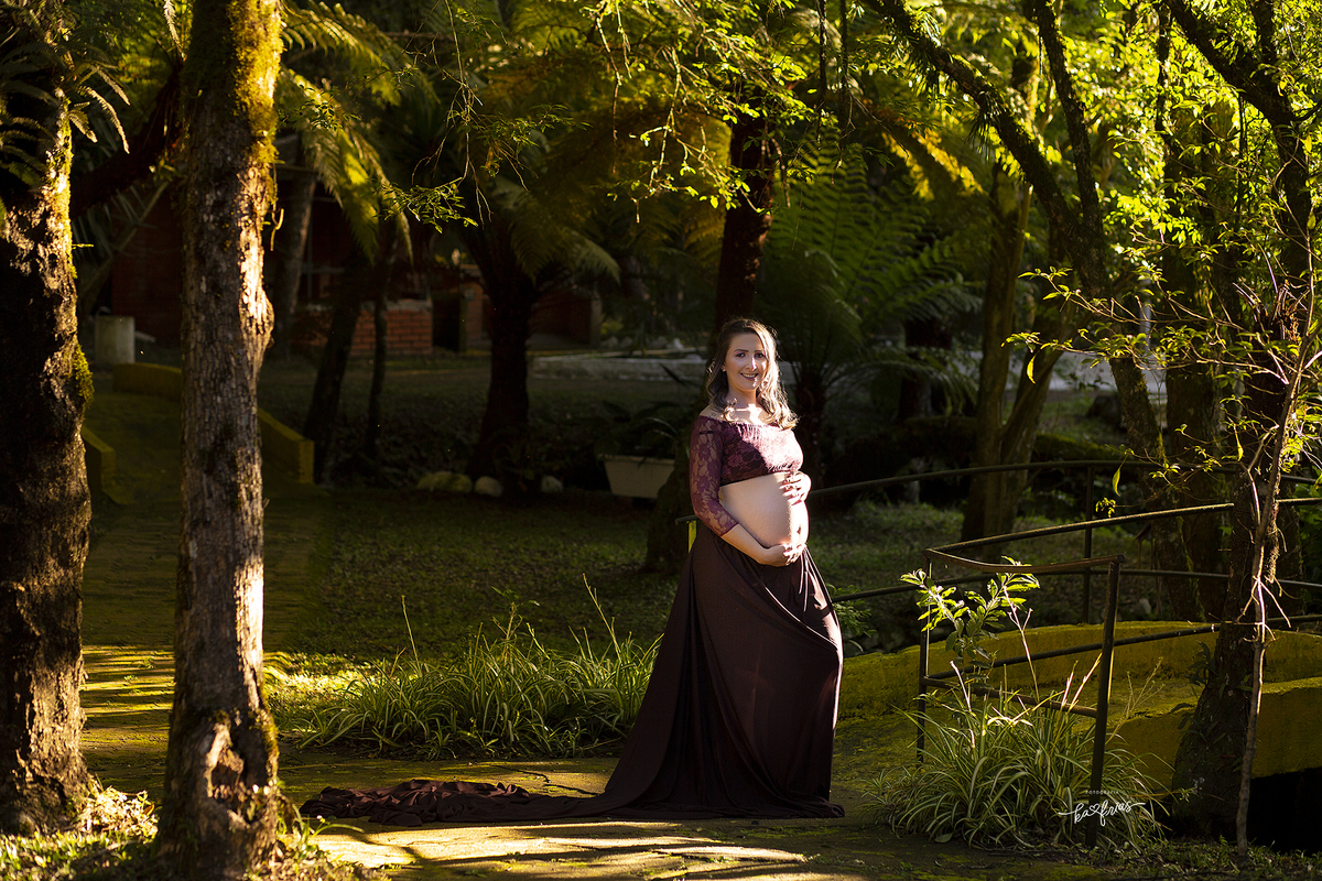 a modelo esta no meio da natureza para as fotos de gestante