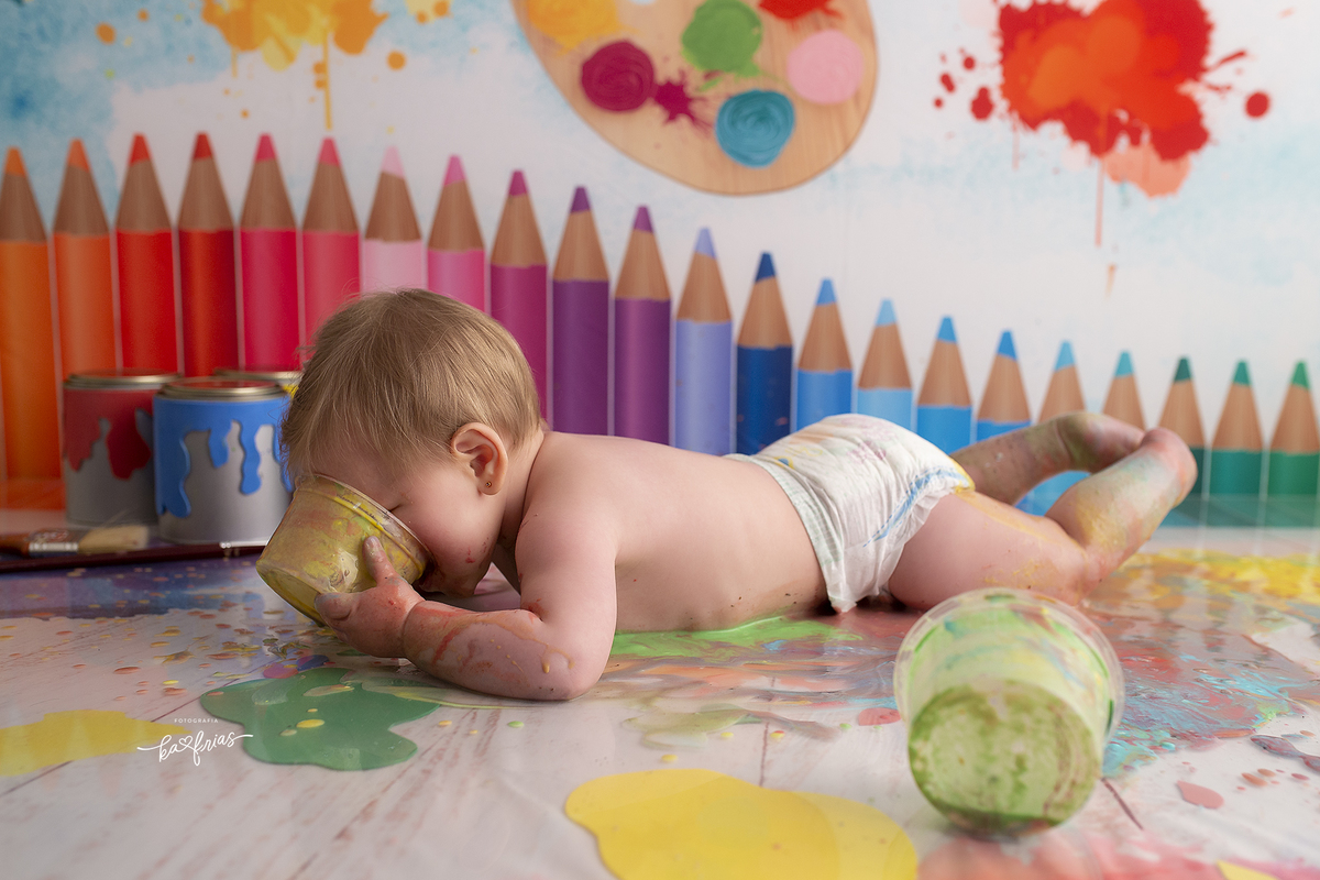 a menina poe a tinta na boca durante sessão infantil